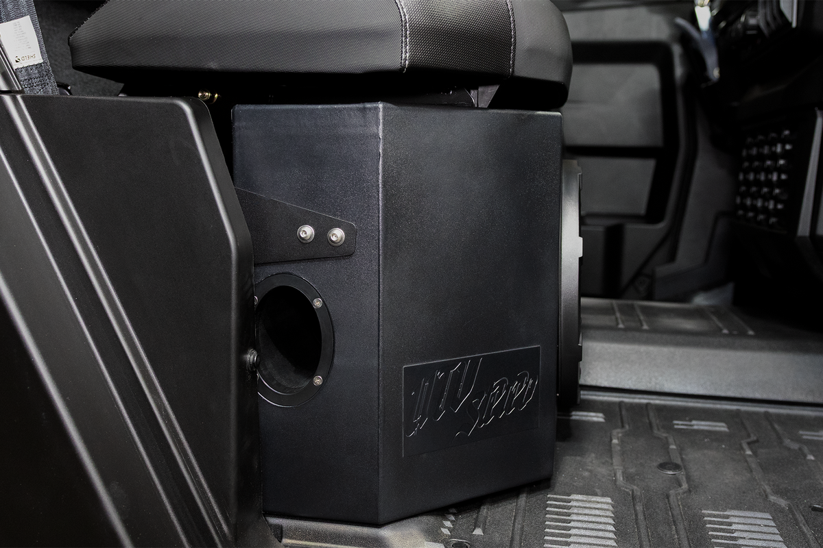 UTV Stereo black subwoofer enclosure installed under a vehicle seat