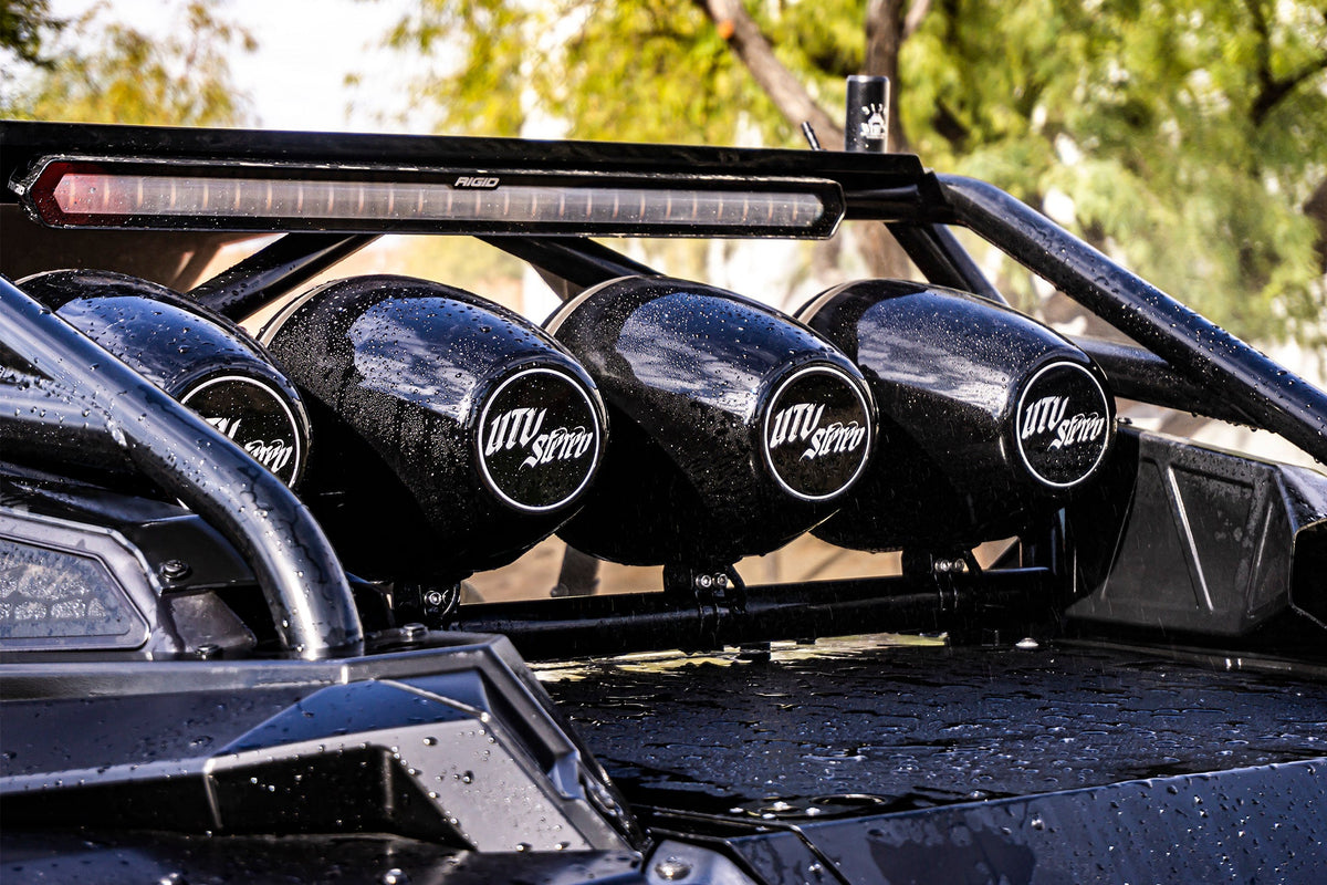 Three black UTV Stereo speakers mounted on a vehicle roll cage