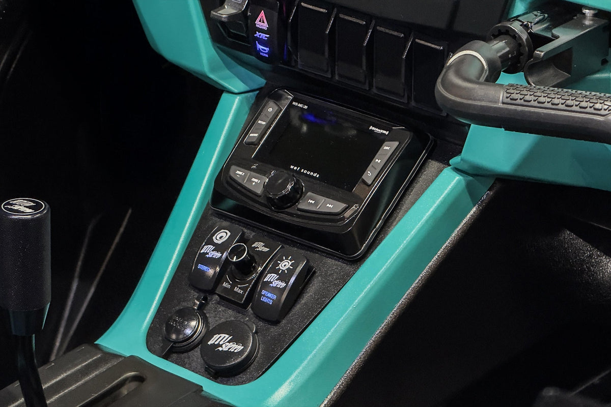 Wet Sounds media center and accessory switches on a teal vehicle dashboard