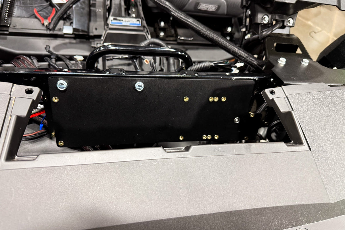 Black metal switch panel mounted on vehicle dashboard frame