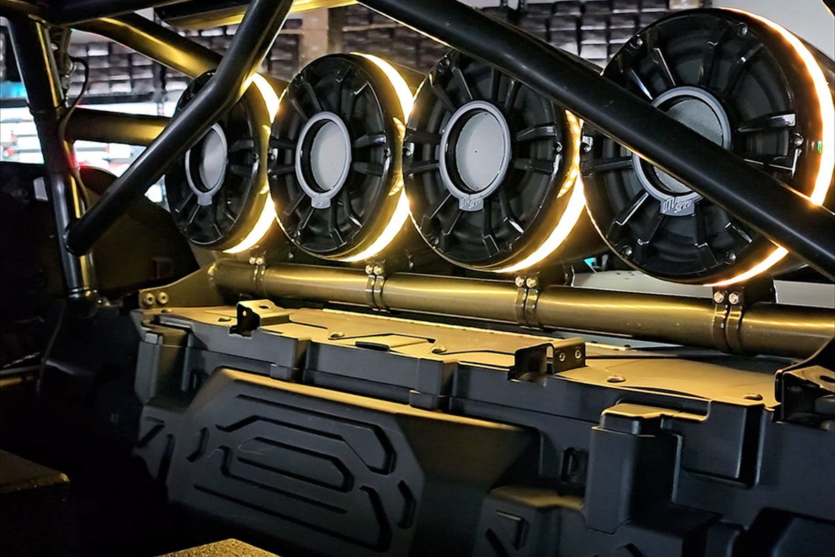 Four circular MTX Audio speakers with glowing yellow LED rings mounted on a roll cage